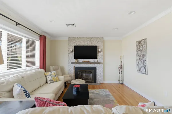 a living room with furniture a flat screen tv and a fireplace