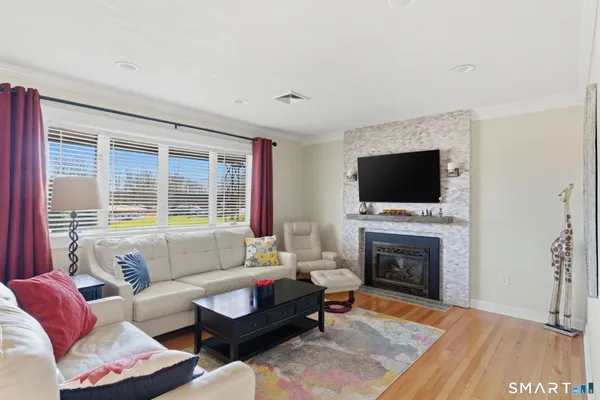 a living room with furniture a flat screen tv and a fireplace