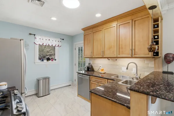 a kitchen with granite countertop a sink a stove and cabinets