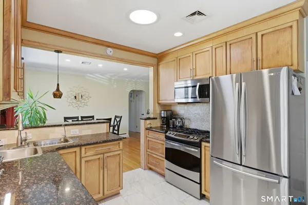 a kitchen with stainless steel appliances granite countertop a refrigerator stove and sink