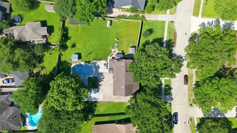 an aerial view of a house with a yard and lake view