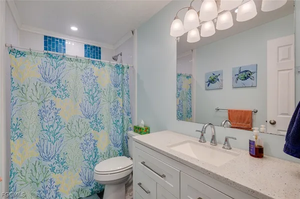 a bathroom with a granite countertop sink a toilet and a mirror