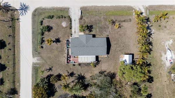 an aerial view of a house with a yard and large tree