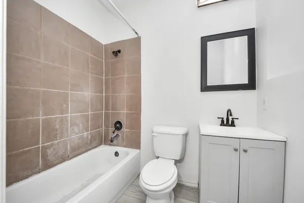 a bathroom with a toilet sink a mirror a bathtub and shower