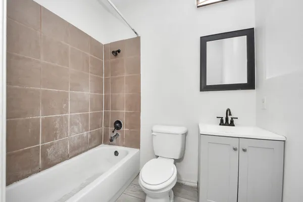 a bathroom with a toilet sink a mirror a bathtub and shower