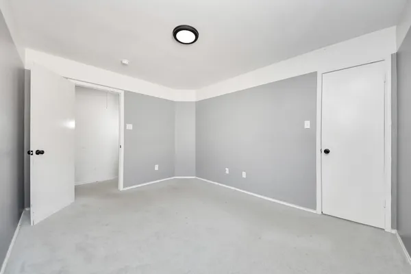 an empty room with a window and a mirror