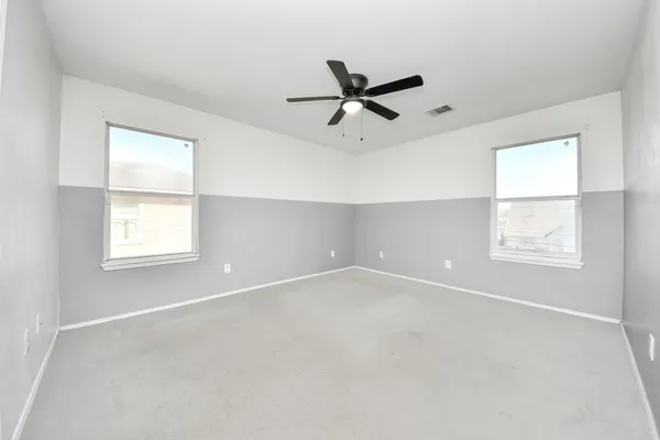 an empty room with a ceiling fan and a window
