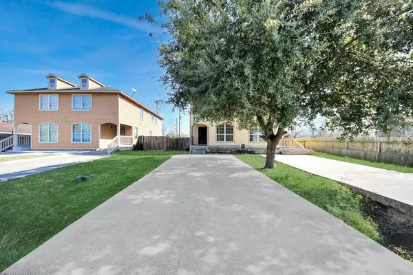 a front view of a house with yard and green space