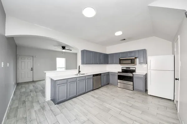 a kitchen with stainless steel appliances a sink dishwasher stove and refrigerator
