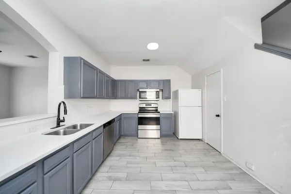a large kitchen with cabinets a sink and a stove