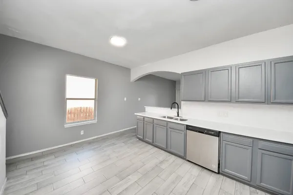 a kitchen with sink cabinets and wooden floor