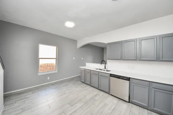 a kitchen with sink cabinets and wooden floor