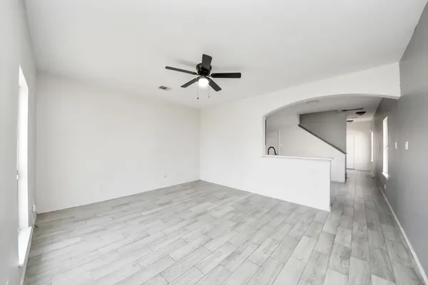 a view of a room with wooden floor and a ceiling fan
