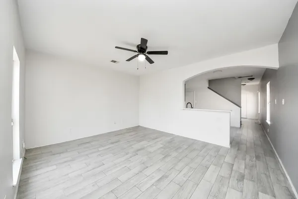 a view of a room with wooden floor and a ceiling fan