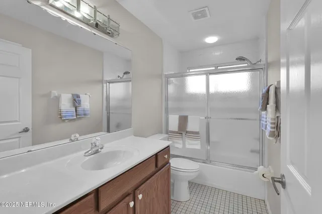 a bathroom with a sink a toilet a mirror and shower