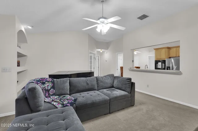 a living room with furniture and a chandelier
