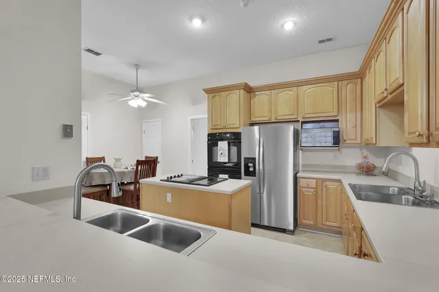 a kitchen with a sink a counter top space stainless steel appliances cabinets and a counter top space