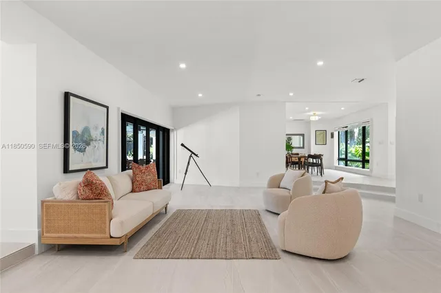 a living room with furniture a flat screen tv and a window
