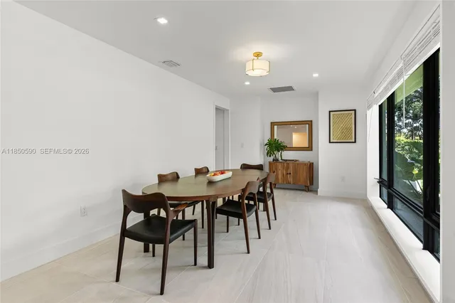 a hallway with white cabinets and wooden floor