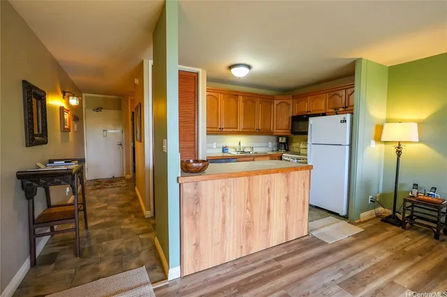a kitchen with stainless steel appliances granite countertop a refrigerator a stove and a sink