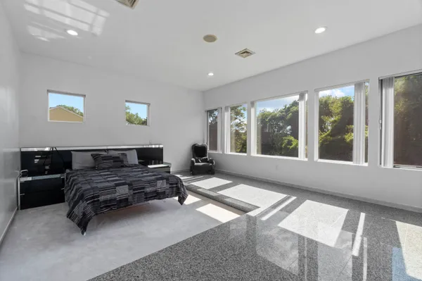 a bedroom with furniture and a large window