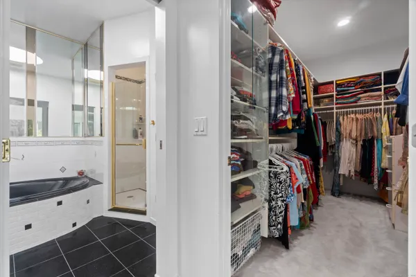 a view of walk in closet with clothes and shoes
