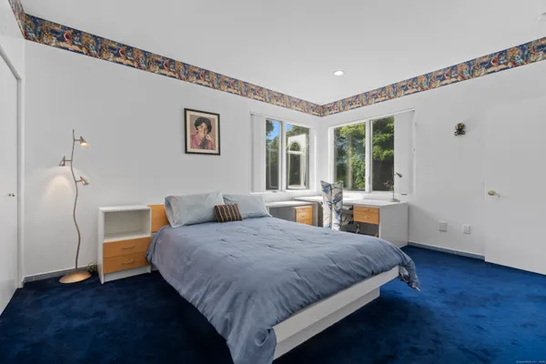 a spacious bedroom with a bed and wooden floor