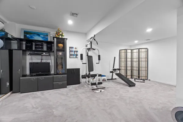 a living room with furniture gym equipment and a window