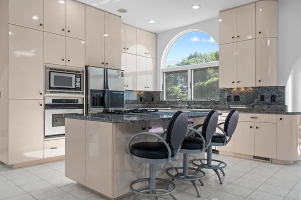 a kitchen with stainless steel appliances granite countertop a stove a sink a microwave and a refrigerator
