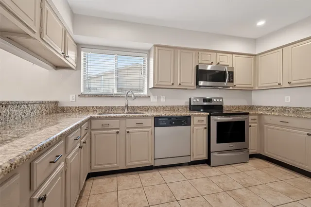 a kitchen with cabinets stainless steel appliances and a window