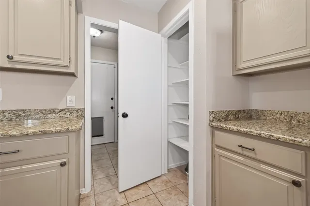 a kitchen with granite countertop cabinets and refrigerator