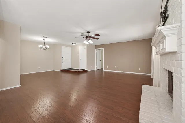 a view of a livingroom with a ceiling fan fireplace and wooden floor