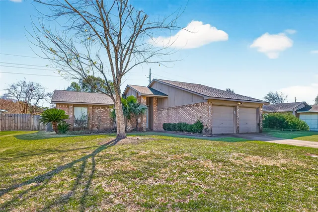 a view of a house with a yard and potted plants