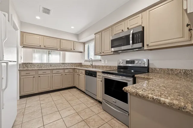 a kitchen with stainless steel appliances granite countertop a sink and a stove