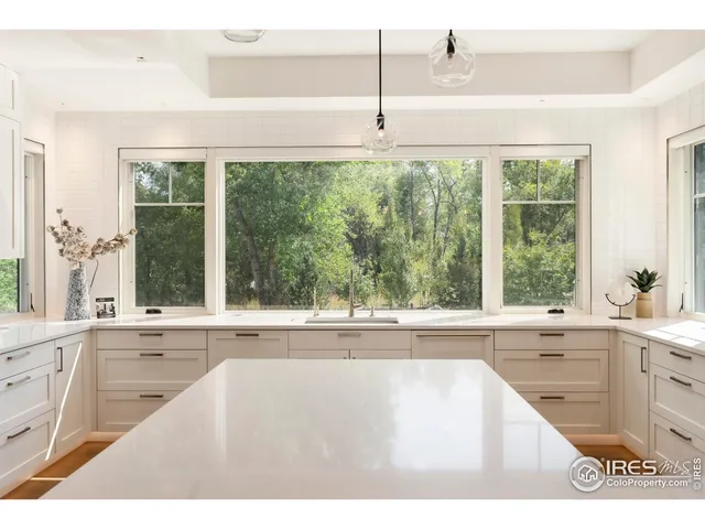 a view of a kitchen with a sink and large window