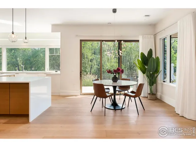 a dining room with furniture window outside view and wooden floor