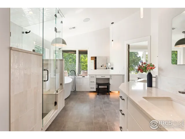 a en suite bathroom with a granite countertop double vanity sink a mirror and a shower
