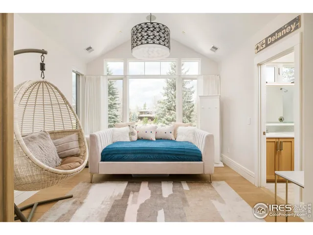 a living room with a bed and a large window