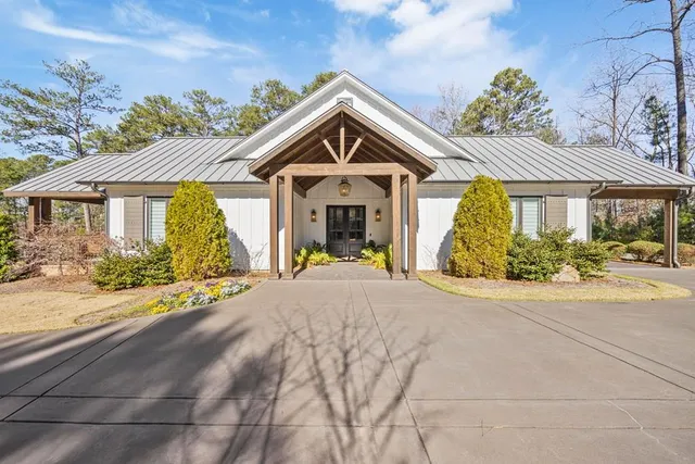 a front view of a house with a yard and potted plants