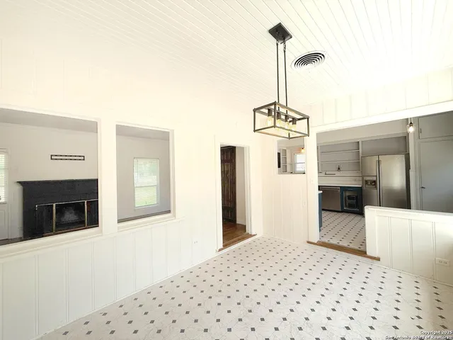 a large white kitchen with granite countertop a sink and a refrigerator