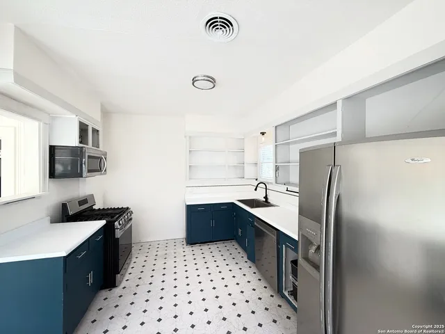 a kitchen with stainless steel appliances a stove a sink and a microwave
