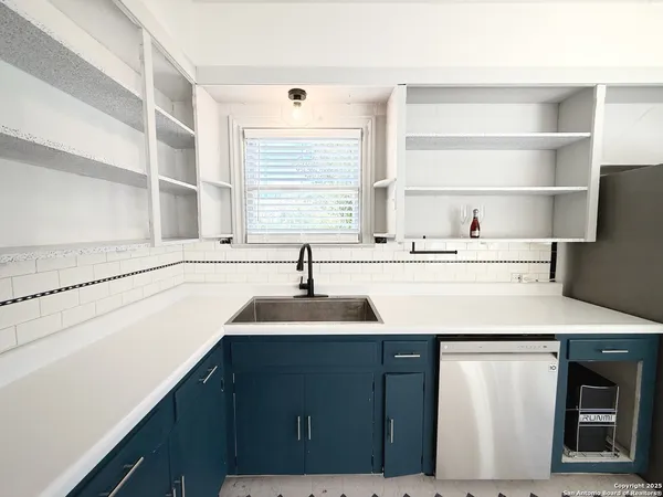 a kitchen with a sink a stove a refrigerator and a window