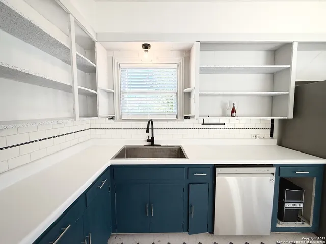 a kitchen with a sink a stove a refrigerator and a window