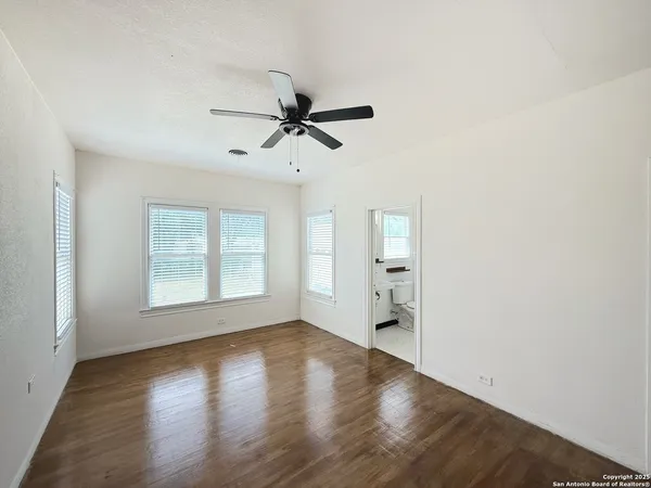 a view of a big room with wooden floor and a ceiling fan