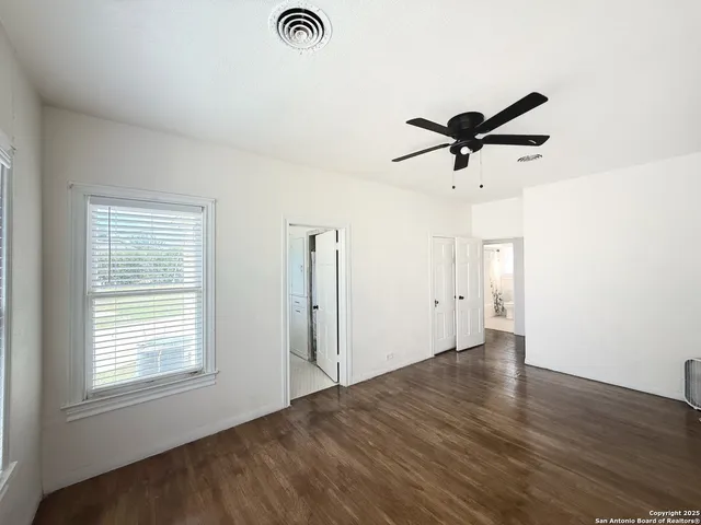 an empty room with a window and a ceiling fan