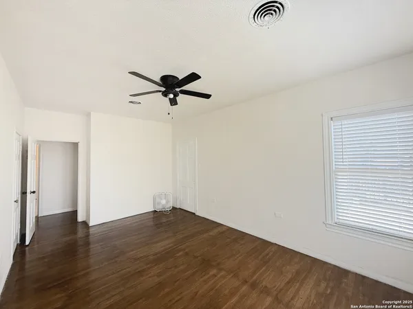 a bathroom with a toilet a sink a mirror and a window