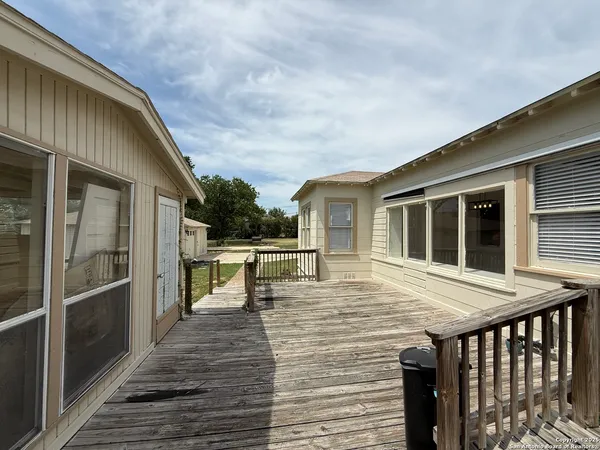 a white house with a big yard and large trees