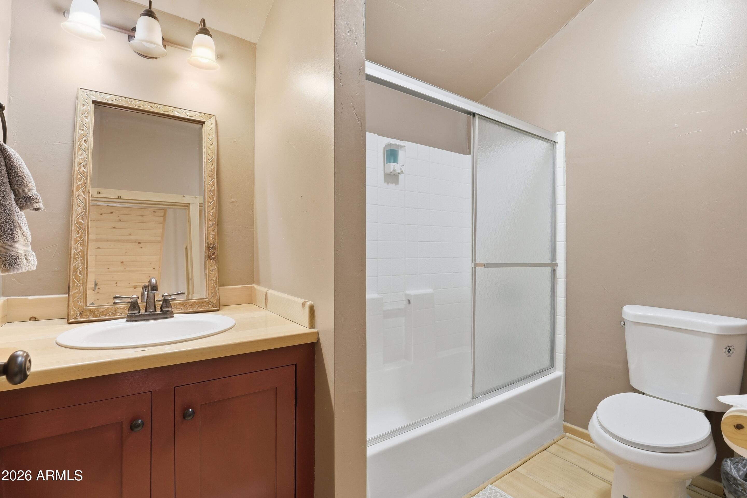 6322 Sharyn Road Pine, AZ 85544 - Photo 23 of 37 a bathroom with a sink a toilet a mirror and shower