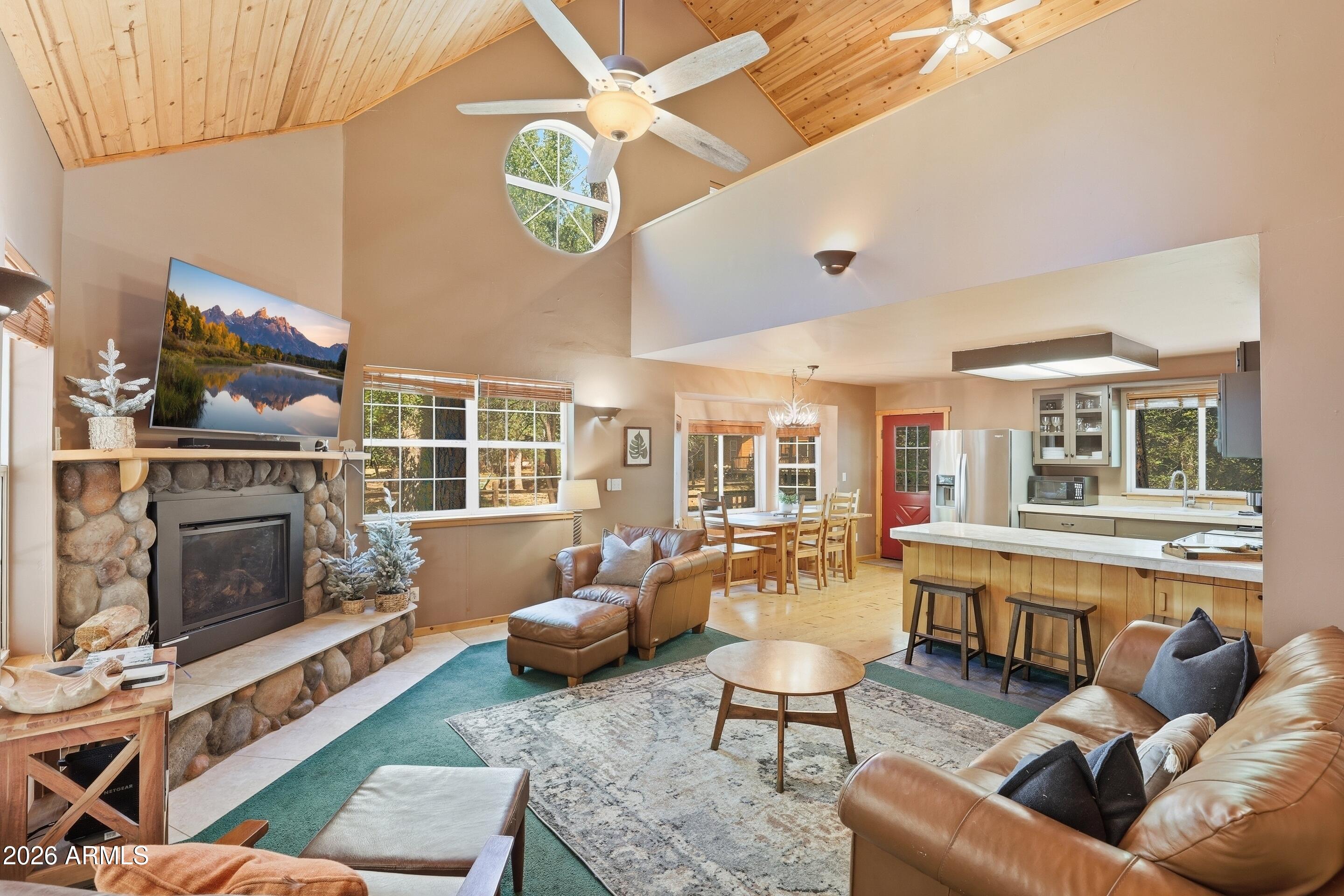 6322 Sharyn Road Pine, AZ 85544 - Photo 5 of 37 a living room with furniture a fireplace and large windows
