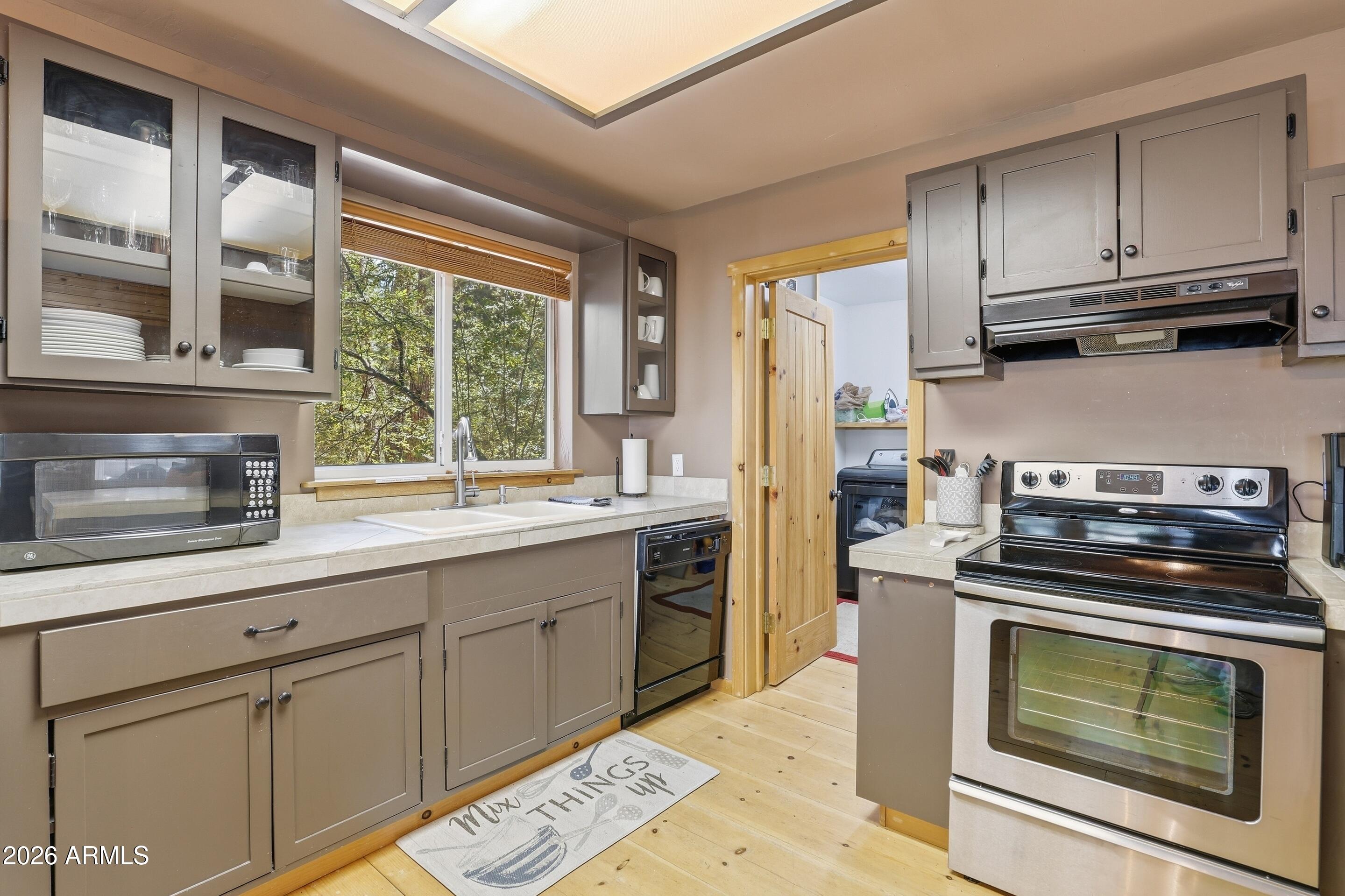 6322 Sharyn Road Pine, AZ 85544 - Photo 10 of 37 a kitchen with stainless steel appliances wooden floor sink and wooden cabinets
